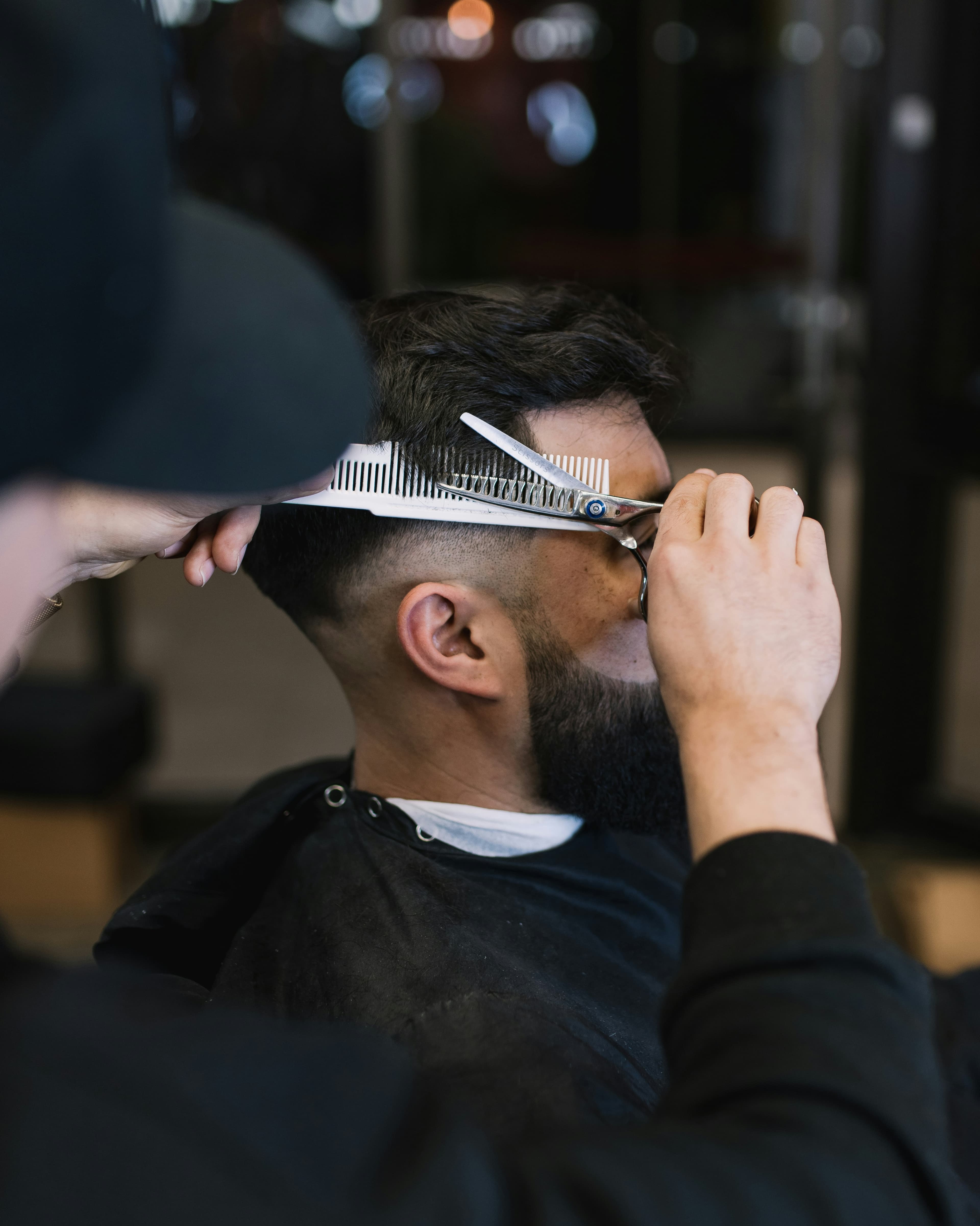 Barber trimming a client's hair